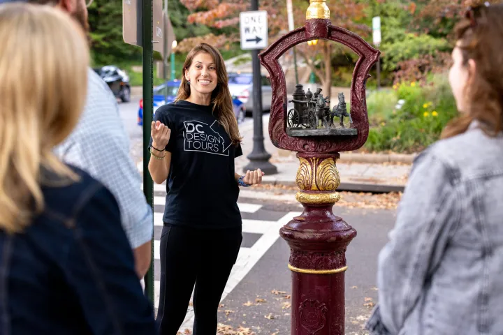 a group of people standing on the sidewalk talking on a cell phone