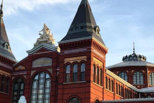 a large brick building with a clock tower with Arts and Industries Building in the background