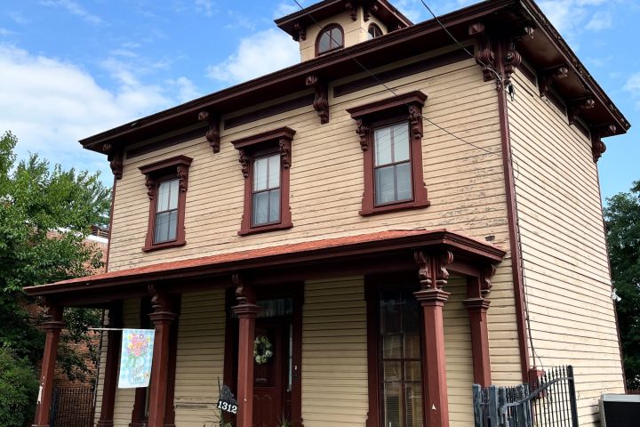 a large brick building with grass in front of a house
