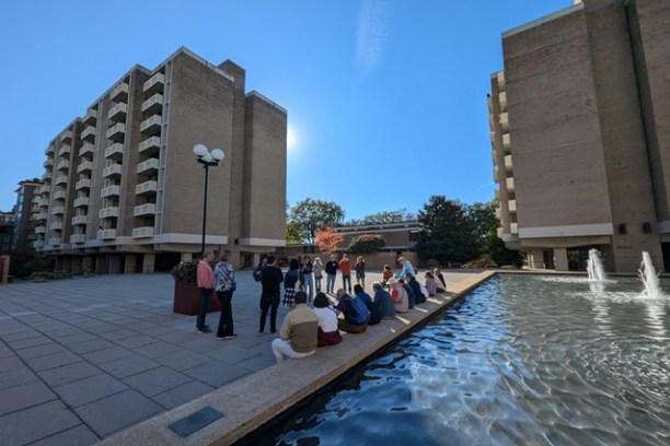 a group of people in a pool of water in front of a building